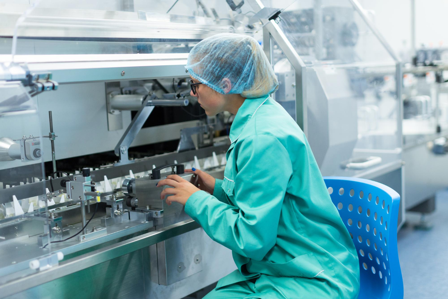 Technician operating a pharmaceutical packaging line